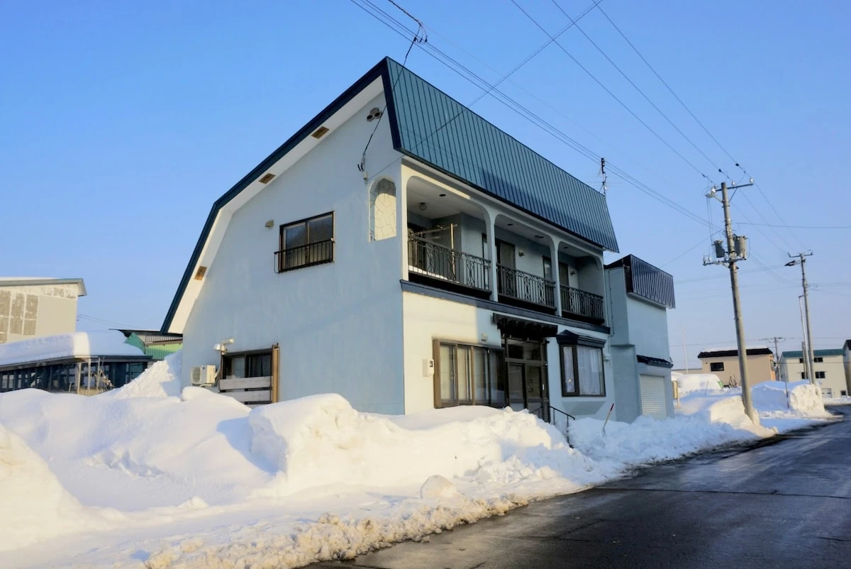 青空と雪に囲まれたキャットふるびらの外観