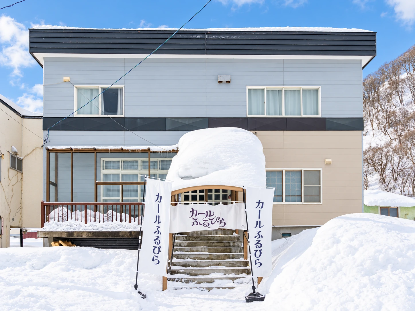 青空の下、雪に囲まれたカールふるびらの外観